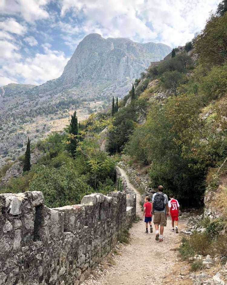 family travel climbing the city walls of Kotor, Montenegro